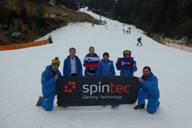 Skupina mlajših in starejših, ki se slikajo z zastavo Spintec, NLB in Slovenije